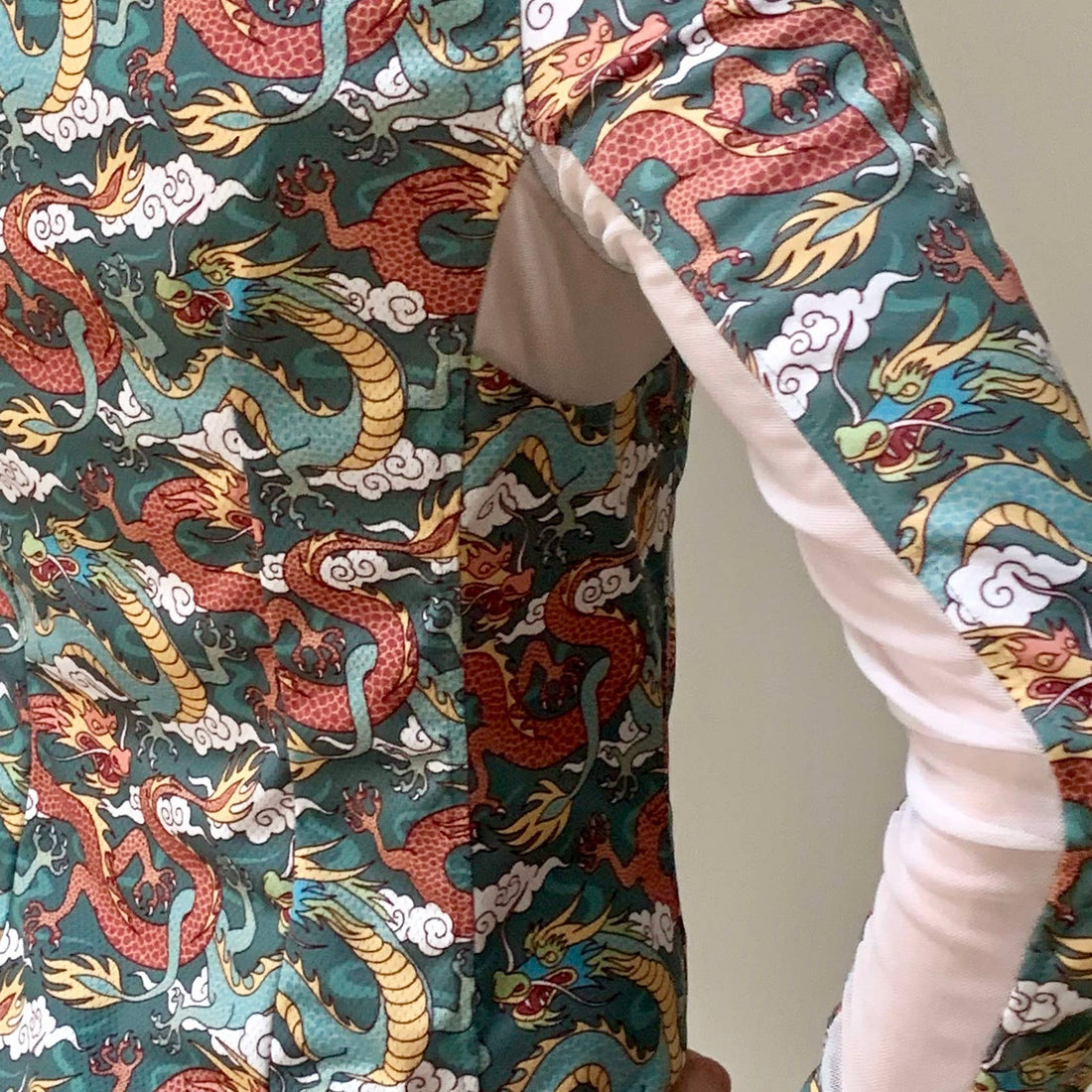 Green/Rust | Long Sleeve Athletic Polo - Dragons, close-up of the dragon print fabric